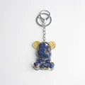 Bear keychain with blue natural crystal stones and gold foil inside a resin mold - Lapis Lazuli