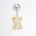 Handmade bear keychain with transparent resin, metallic gears and purple dried flowers - Opal Style