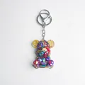 Bear keychain crafted with transparent resin, colorful crystals, and golden gear accents - Colorful Shell Style
