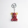 Red crystal bear keychain with gold foil and gear detail on a white background - Coral Stone Style