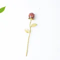 Red crystal stone resin rose figurine with gold metal stem on white textured background - Red Jasper