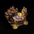 Dragon turtle resin statue with amber crystal gravel and gold foil on black background - Tiger's Eye
