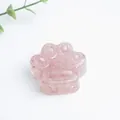Detailopname van een roze hars kattenpoot ornament met decoratieve goudfolie snippers - Rozenkwarts