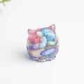 Adorno de resina con forma de gato y cristales coloridos en azul translúcido y violeta - Concha de Abulón
