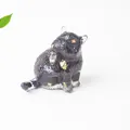 Statuina di gatto nero con accenti in foglia d'oro in postura che si gratta - Ossidiana