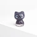 Cute dark purple resin cat figurine with large blue eyes and a crystal stone base - Garnet