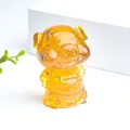 Détail macro d'une figurine de cochon en résine avec feuilles d'or et pierres de cristal - Citrine