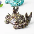 Handmade resin crab phone stand with natural crystal stones and gold foil details - Dragon Blood Stone