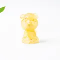 Close-up of a translucent yellow resin kitten figurine with amber texture and cute details - Topaz
