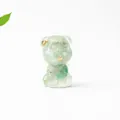 Macro shot of Schnauzer crystal resin decor with gold flakes and a green leaf background - Aventurine Jade
