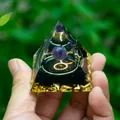 Makro-Detail einer Harzkristall-Pyramide mit Amethyst-Kugel und goldenen Tierkreiszeichen - Stier