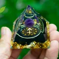 Macro detail of Sagittarius zodiac crystal pyramid with amethyst ball and gold foil flakes - Sagittarius
