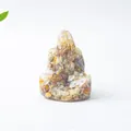 Primer plano de cristales naturales coloridos incrustados en una figura de resina suave - Ágata Loca Buda