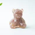 Macro di una statuetta di orso con pietre di cristallo rosa naturali in resina - Quarzo Fragola