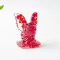 Vue détaillée d'une figurine de gargouille en résine rouge translucide avec textures internes - Verre Rouge