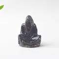 Macro shot of dark translucent crystal resin wizard ghost figurine on a stone surface - Obsidian Ghost Wizard