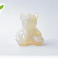 Dettaglio di una statuetta di orso in resina trasparente e pietre di cristallo naturali - Opale