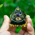 Libra crystal orgone pyramid with amethyst and gold foil in a hand for scale - Libra