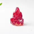 Primer plano de estatua de mago fantasma en resina roja con virutas de pan de oro - Buda de Cristal Rojo