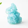 Close-up of a blue resin elephant figurine with embedded natural crystal stones - Aquamarine