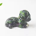 Detail of a dog statue made of ruby in zoisite crystal stone on a clean white background - Ruby Zoisite