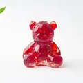 Dettaglio di una statuetta di orso in resina di cristallo rosso traslucido lucido - Vetro Rosso