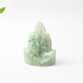 Vista macro de una pequeña figura zen decorativa con piedras de cristal verde naturales - Aventurina Verde Buda