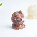Macro shot of resin lion figurine filled with red-brown natural crystal stones and minerals - Red Agate