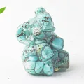 Macro detail of turquoise elephant figurine with natural stone textures on white surface - Turquoise