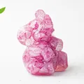 Macro shot of pink crystal resin elephant statue on a clean white leather surface - Rose Red Crystal