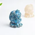 Detail of blue natural crystal stone and resin lion figurine with light reflecting finish - Apatite
