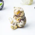 Dettaglio di una statuetta di gatto in resina trasparente con petali di fiori essiccati - Agata Pazza