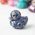 Macro-opname van hars eendje beeldje met blauwe kristalstenen en gouden schilfers - Lapis lazuli / Klein Formaat 38 Mm