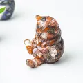 Dettaglio di statuetta a forma di gatto in resina con pietre naturali colorate - Agata rossa