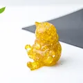 Dettaglio macro di statuetta a forma di gatto in resina trasparente e cristalli gialli - Citrino