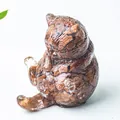 Dettaglio macro di una statuetta di gatto in resina con pietre naturali decorative - Pietra sand oro
