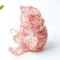 Dettaglio ravvicinato di una statuina di gatto portafortuna in resina con cristalli rosa - Quarzo Cocomero