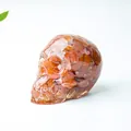 Skull resin ornament with orange natural crystal stones and high gloss finish - Red Agate