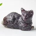 Figura de gato hecha de astillas de cristal natural púrpura y resina en posición tumbada - Granate
