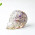 Skull figurine made of clear resin with embedded natural purple crystal stones - Colorful Fluorite
