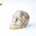 Skull figurine made of transparent resin filled with yellow and black natural crystal stones - Rutilated Quartz