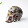 Crystal resin skull decor with green and reddish-brown natural stone inclusions - Dragon Blood Stone
