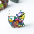 Gros plan d'une figurine de chat en résine avec des cristaux naturels multicolores - Coquillage Coloré
