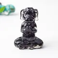 Detailed macro view of a black resin meditation dog statue with polished gemstone finish - Obsidian