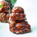 Laughing Buddha statue filled with natural red jasper crystals in transparent resin - Red Jasper