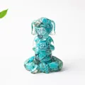 Macro detail of meditating dog figurine made with turquoise stone chips and clear resin - Turquoise