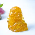 Laughing Buddha figurine in translucent yellow amber resin holding a gold ingot - Citrine