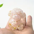 Mini statuetta di cane teddy in resina rosa con foglie d'oro nel palmo di mano - Quarzo rosa