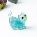 Figurine chat en cristal bleu avec motif craquelé et grands yeux jaunes expressifs - Aigue-marine