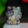 Macro shot of purple and green resin stone guardian lion statue with gold rich engraving - Colorful Fluorite